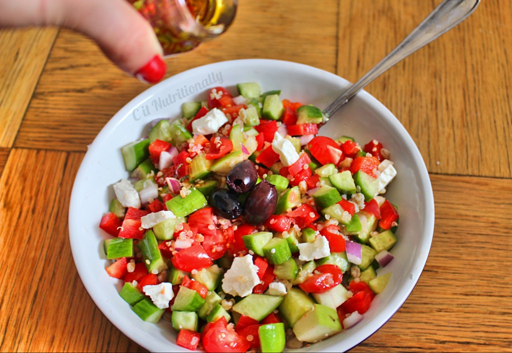 Greek quinoa salad with dressing pour